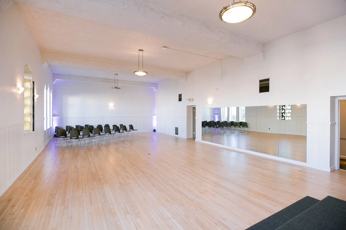 Ensemble Room with an open wood floor, mirrors and chairs along the wall