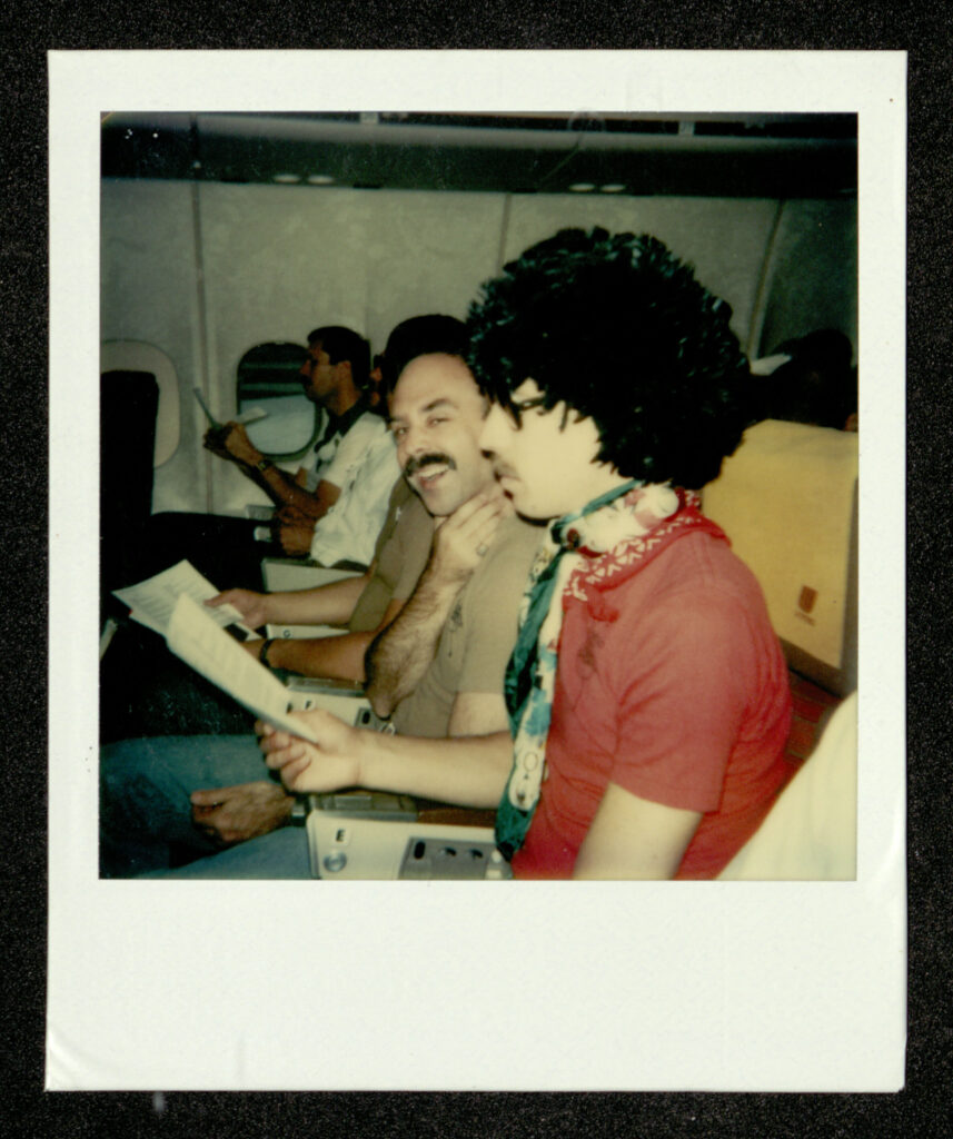 sfgmc-archive-23778-full Chorus members rehearse on the plane during the June 1981 national tour. Bill Graham photograph album. Courtesy GLBT Historical Society, via Calisphere.